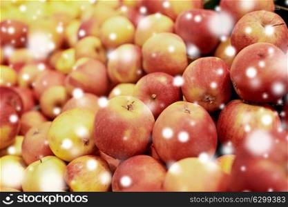 fruits, harvest, food and sale concept - ripe apples at grocery store or market over snow. ripe apples at grocery store or market