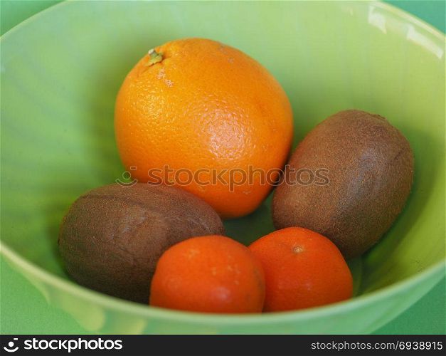 fruits in plastic bowl. many fruits in plastic bowl, including orange, kiwi and tangerine