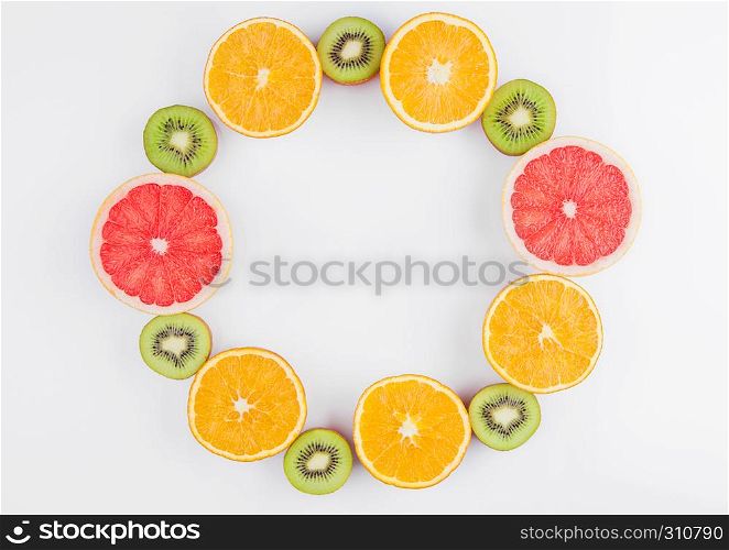 Fruits mix grapefruit orange and kiwi close up on white