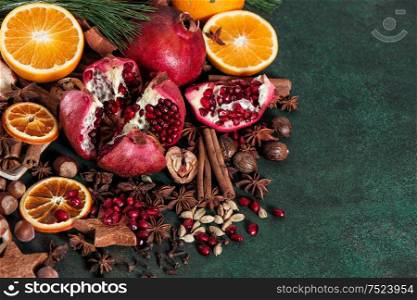 Fruits pomegranate and orange with spices and ingredients for mulled wine cinnamon, star anise, cardamon, nutmeg