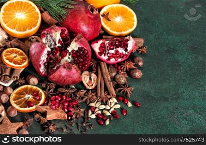 Fruits pomegranate and orange with spices and ingredients for mulled wine cinnamon, star anise, cardamon