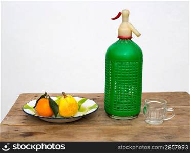 fruits tangerine and pear in vintage porcelain dish with retro soda bottle