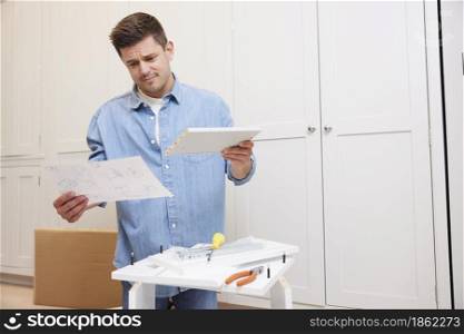 Frustrated And Confused Man Reading Instructions And Putting Together Self Assembly Furniture At Home