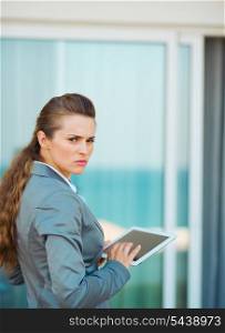 Frustrated business woman using tablet pc