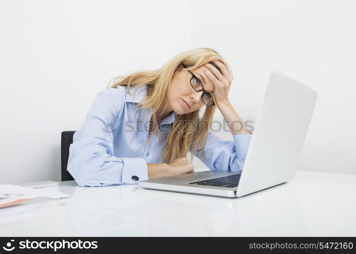 Frustrated businesswoman looking at laptop in office