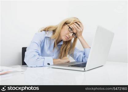 Frustrated businesswoman looking at laptop in office