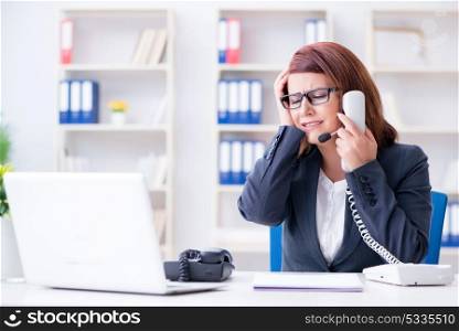 Frustrated call center assistant responding to calls. The frustrated call center assistant responding to calls