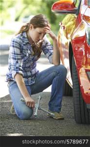Frustrated Female Driver With Tyre Iron Tring To Change Wheel