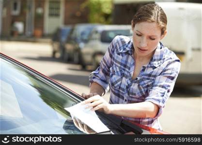 Frustrated Female Motorist Looking At Parking Ticket
