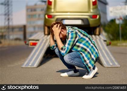 Frustrated man has car problem. Guy feeling stress while tow truck takes his car to auto repair shop. Frustrated man having car problem on road