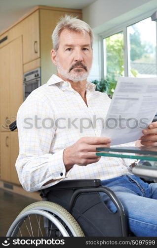 Frustrated Man In Wheelchair Reading Letter