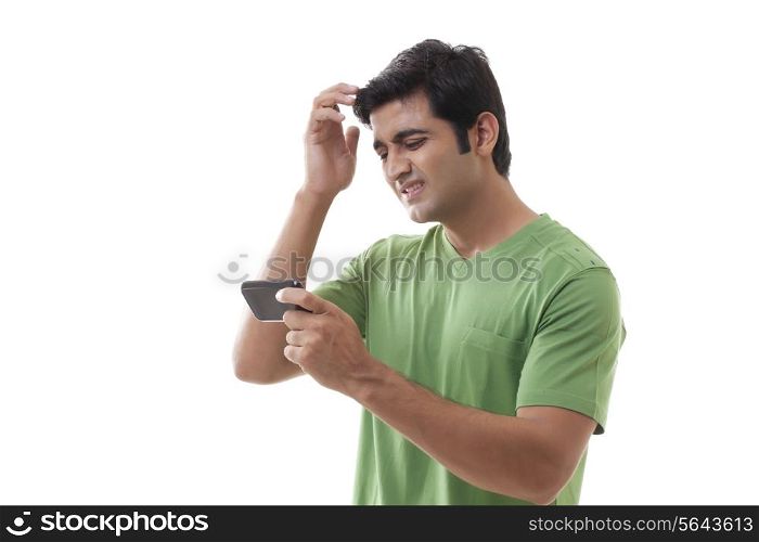 Frustrated man with cellular phone on white background