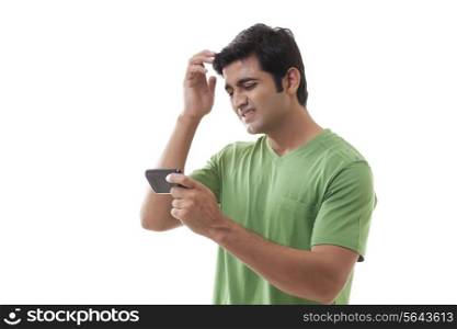 Frustrated man with cellular phone on white background