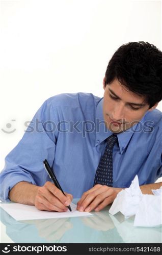 Frustrated man writing at desk