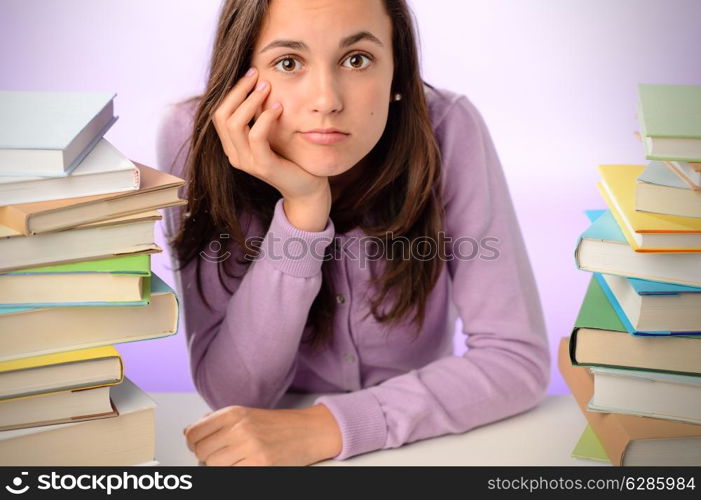Frustrated student girl sitting between stacks of books purple background