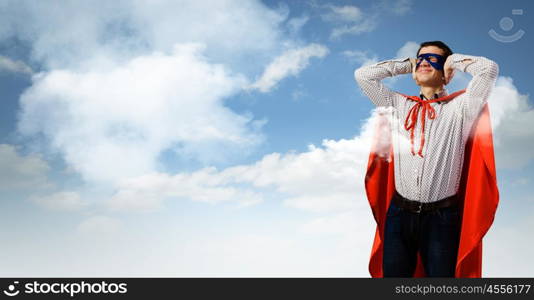 Frustrated superman. Young man in hero costume closing ears with palms