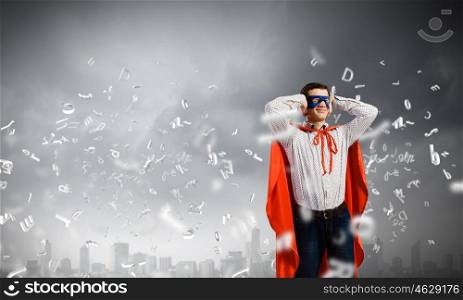 Frustrated superman. Young man in hero costume closing ears with palms