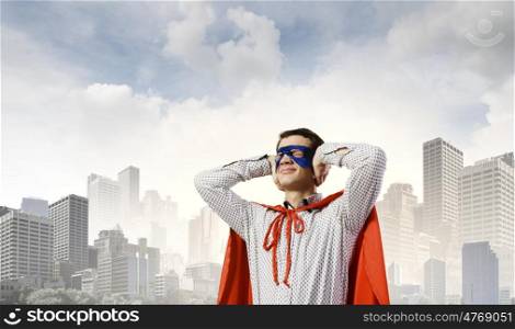 Frustrated superman. Young man in hero costume closing ears with palms