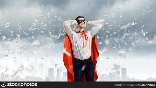 Frustrated superman. Young man in hero costume closing ears with palms