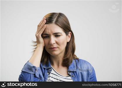 Frustrated woman holding head in hands and expressing pain