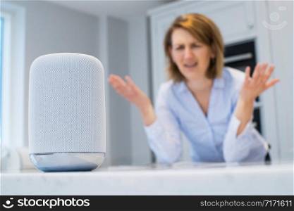 Frustrated Woman In Kitchen Asking Digital Assistant Question