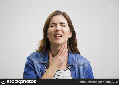 Frustrated woman in pain with a sore throat