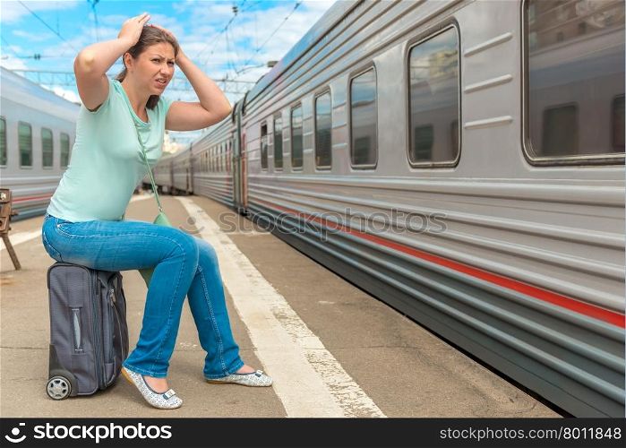 frustrated woman looking at the passing train on which she was late