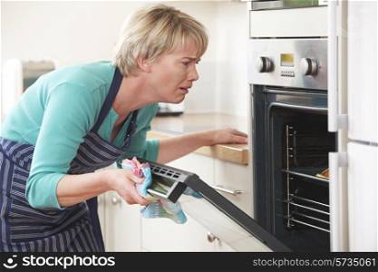 Frustrated Woman Looking In Oven With Disappointed Expression