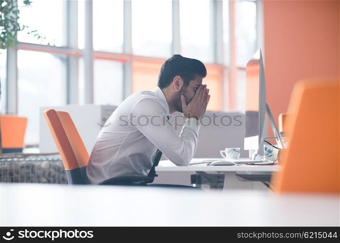 frustrated young business man working on desktop computer at modern startup office interior
