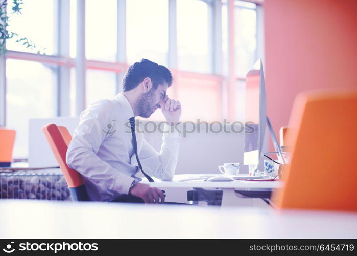 frustrated young business man working on desktop computer at modern startup office interior