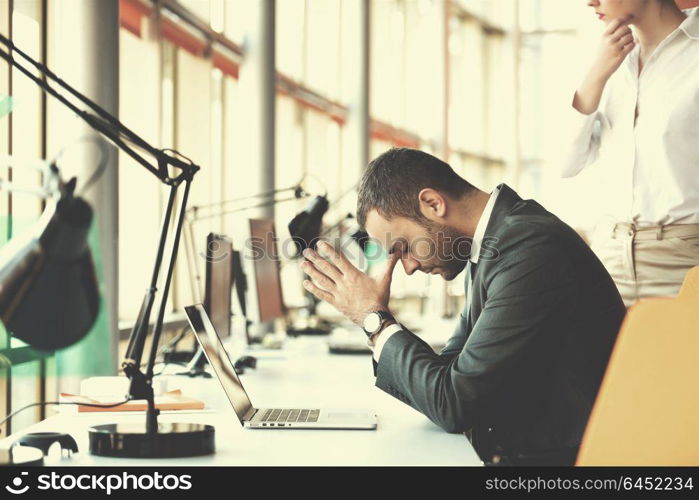 frustrated young business man working on laptop computer at office