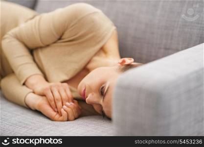 Frustrated young housewife laying on couch