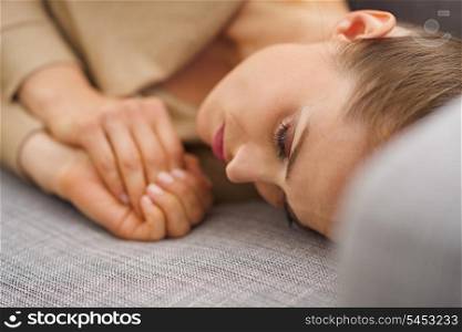 Frustrated young housewife laying on sofa