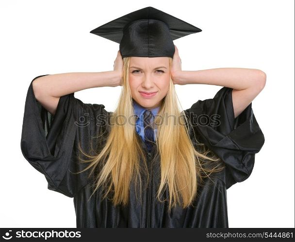 Frustrated young woman in graduation gown closing ears