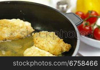 frying chicken breast roll on a frying pan. Closeup