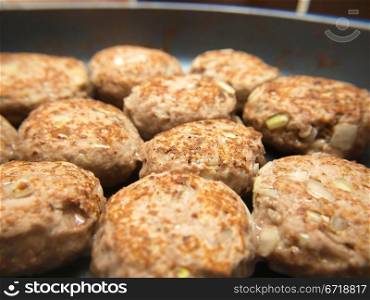 Frying many meatballs, isolated in a frying pan