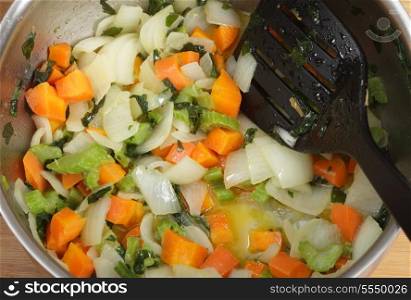 Frying onion, carrot and celery as part of the process of making a risotto