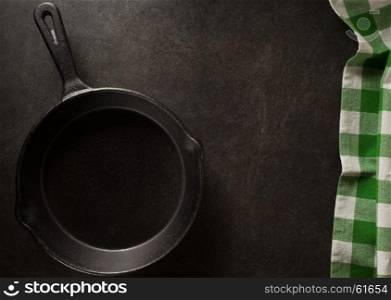 frying pan and napkin on black background