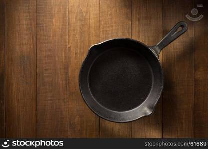 frying pan on wooden background texture