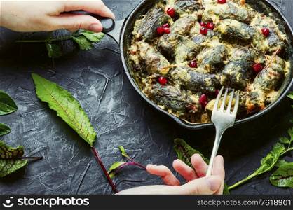 Frying pan with cooked oriental dolma in hands.Appetizing oriental food.Dolma in grape leaves.. Eastern dolma or sarma