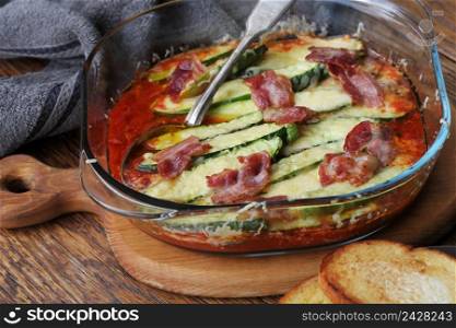 Frying pan with fried tomatoes, zucchini, cheese and herbs on wooden cutting board .. Frying pan with fried tomatoes, zucchini, cheese and herbs on wooden cutting board