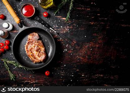 Frying pan with grilled steak. Against a dark background. High quality photo. Frying pan with grilled steak.