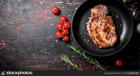 Frying pan with grilled steak. Against a dark background. High quality photo. Frying pan with grilled steak.