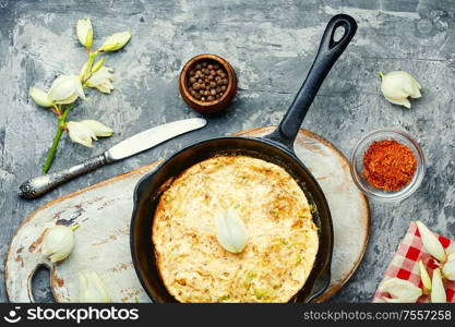 Frying pan with scrambled eggs stuffed with edible yucca flowers.American food. Omelet with edible flowers