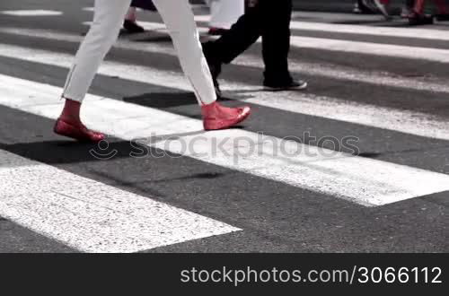 Fu?ganger uberqueren eine Stra?e an einem Zebrastreifen, pedestrians cross a road on a zebra crossing