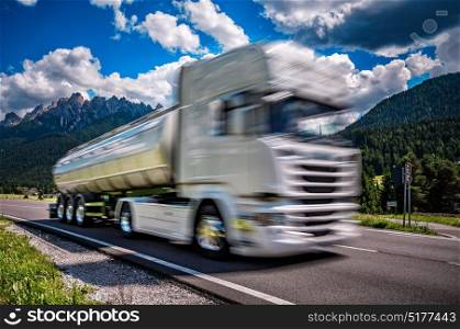 Fuel truck rushes down the highway in the background the Alps. Truck Car in motion blur.
