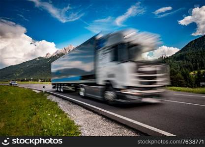 Fuel truck rushes down the highway in the background the Alps. Truck Car in motion blur.