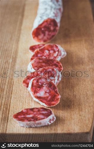 Fuet - Catalan dry cured sausage on the wooden board