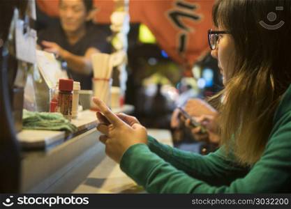 FUKUOKA, JAPAN - SEPTEMBER 29, 2017: People eating Yatai mobile food stall at night in Fukuoka, Kyushu, Japan