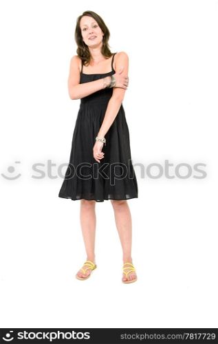 Full body portrait of a young brunette woman in a black summer dress, holding her arm being self aware